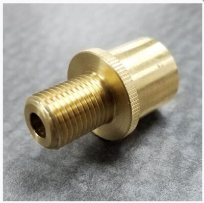 Brass threaded connector on gray background.