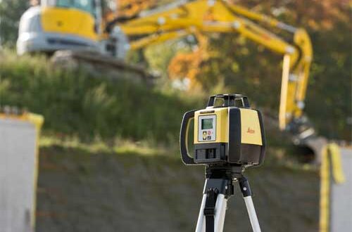A construction site with a Leica Rugby 680 Rotating Laser in the background.