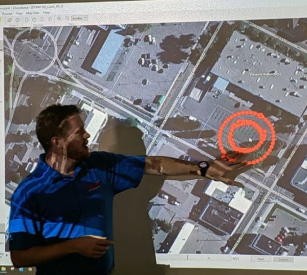 Man pointing at a map on screen.