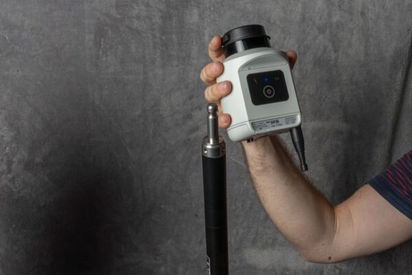 A man holding up a Leica AP20 AutoPole Kit with a tripod.