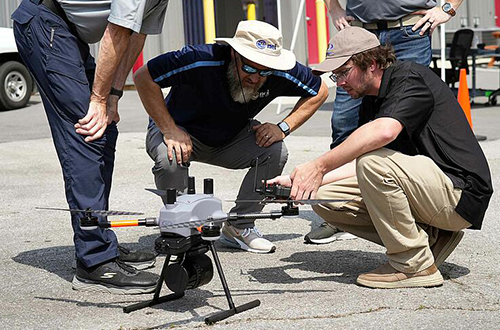 A group of men looking at a drone.