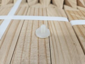 White plastic screw on wood planks.