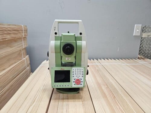 Surveying instrument on wooden surface indoors.