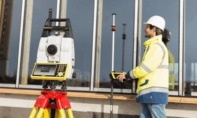Surveyor using equipment on construction site.