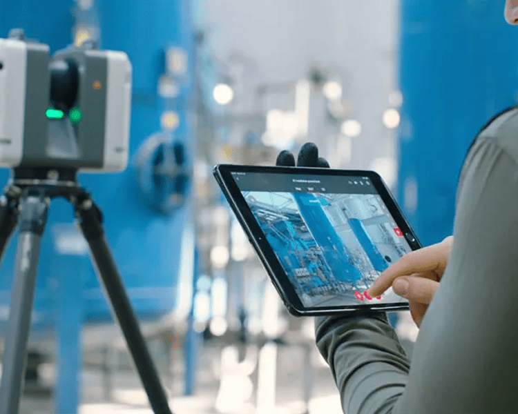 Person using tablet near industrial equipment.