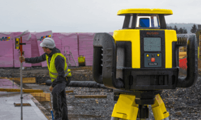 Surveyor using equipment on construction site.
