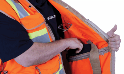 Person reaching into an orange jacket pocket.