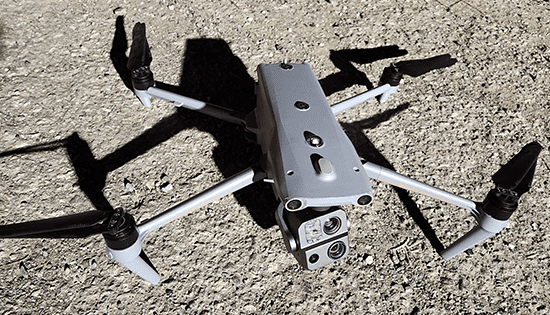 Gray drone on a gravel surface.