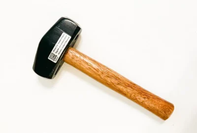Wooden-handled black sledgehammer on white background.