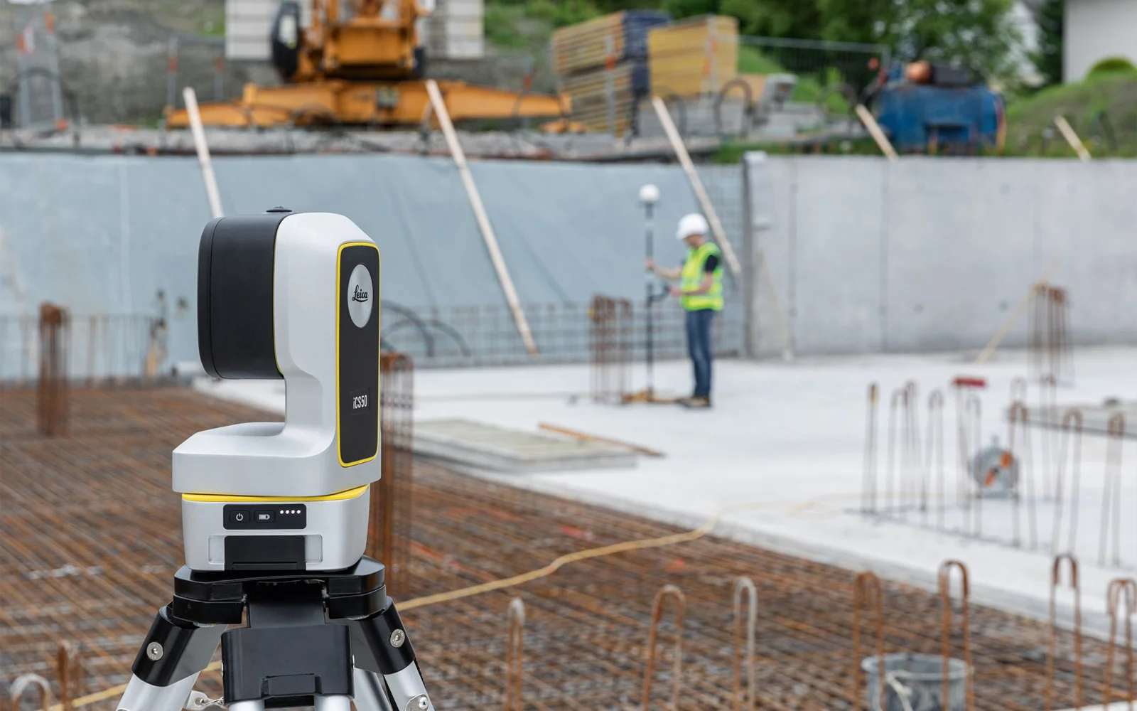 Surveying equipment on construction site with worker.
